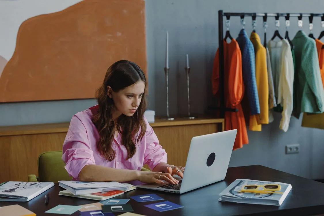 Professional shaping a business offer while working at a laptop in a colorful studio