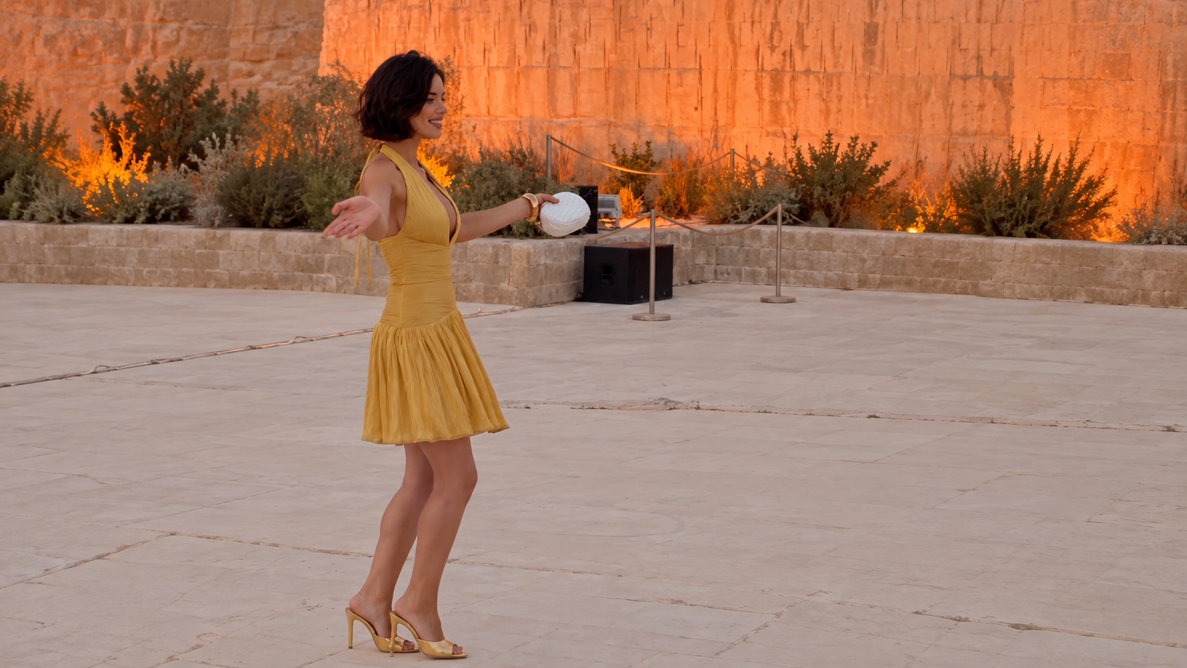Lila Rubin in a yellow dress at a stone courtyard fashion event