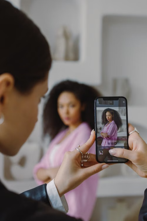 A fashion content producer framing a model on a smartphone